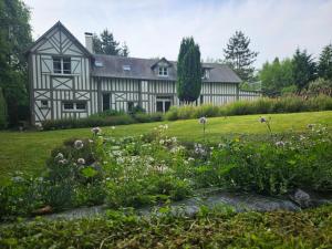 una casa antigua con un jardín delante de ella en Authentique Maison Normande avec Piscine, en Tourgéville