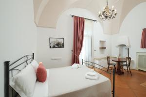 a bedroom with a white bed and a table at Masseria Borgo Santuri in Ostuni