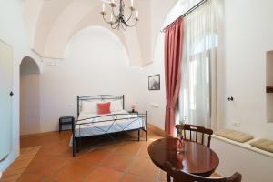 a bedroom with a bed and a table and a dining room at Masseria Borgo Santuri in Ostuni