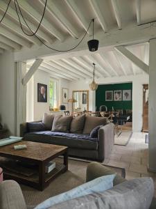 sala de estar con sofá y mesa en Authentique Maison Normande avec Piscine, en Tourgéville