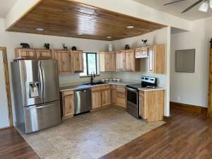 a kitchen with wooden cabinets and stainless steel appliances at Rainbows End Fishing Resort in Pinetop-Lakeside