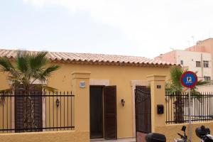 una casa amarilla con una puerta y una palmera en TRIANA_Villa in Palma city with private pool - ETV/10914, en Palma de Mallorca