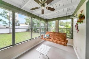 a bench in a room with windows and a ceiling fan at Beach Haven by Emerald Coast Retreats in Panama City Beach