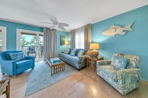 a living room with blue walls and a couch and chairs at Beach Haven by Emerald Coast Retreats in Panama City Beach +25 photos