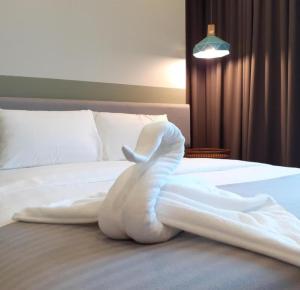 - un animal de serviettes blanches est installé sur le lit dans l'établissement Anggun Residence KL by F&F, à Kuala Lumpur