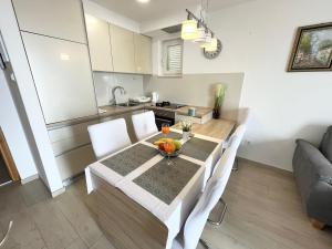 kuchnia i jadalnia ze stołem i krzesłami w obiekcie Apartments Irma w Baskiej Vodzie