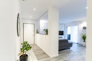 a white living room with a couch and a mirror at Residenza The Rock in Nago-Torbole