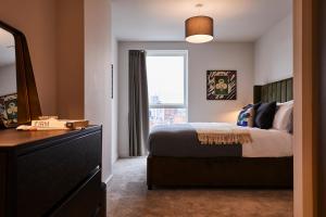 Un dormitorio con una cama y una cómoda y una ventana. en Charles Hope Manchester Centre, en Mánchester