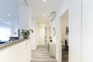 a white hallway with a kitchen and a dining room at Residenza The Rock in Nago-Torbole
