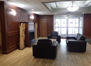 a living room with couches and a fire place at Days Inn by Wyndham Sudbury & Conference Centre in Sudbury