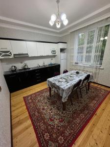 a kitchen with a table and a kitchen with white cabinets at Peak Paradise Gabala Villa in Gabala