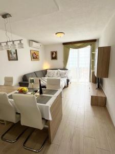 a living room with a couch and a table with chairs at Apartments Irma in Baška Voda