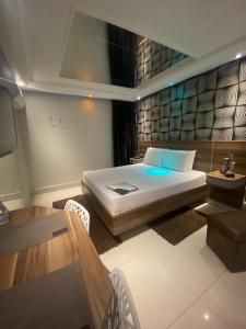 Un dormitorio con una cama grande y una mesa. en Motel My Flowers, en São Paulo