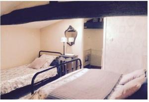 ein Schlafzimmer mit einem Bett und einer Lampe auf einem Tisch in der Unterkunft Le Clos du Gâts Gîte de charme en Vendée à 15 mn du Parc du Puy duFou in La Gaubretière