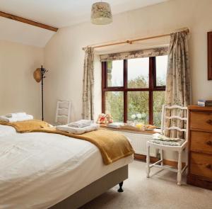 מיטה או מיטות בחדר ב-Trysor Holiday Cottage, Coach House with sea views