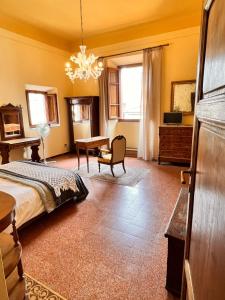 una camera da letto con un letto, una scrivania e un tavolo di Al Palazzo del Capitano - Dimora storica a Pistoia