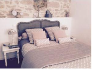 ein Schlafzimmer mit einem Bett mit Kissen darauf in der Unterkunft Le Clos du Gâts Gîte de charme en Vendée à 15 mn du Parc du Puy duFou in La Gaubretière