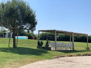 eine Gruppe von Stühlen unter einem Pavillon auf einem Feld in der Unterkunft Le Clos du Gâts Gîte de charme en Vendée à 15 mn du Parc du Puy duFou in La Gaubretière + 11 Fotos