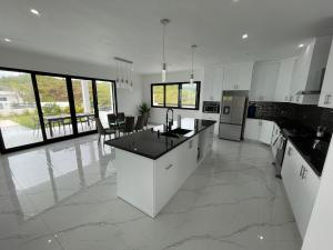 une cuisine avec des armoires blanches et un comptoir dans l'établissement VILLA FLORENCE HOYO CACAO, à Las Terrenas