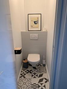 a small bathroom with a toilet and a tile floor at Hôtel L'Estran in Trouville-sur-Mer