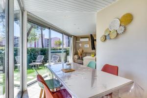 une salle à manger avec une table et des chaises blanches dans l'établissement Appartement rez de jardin climatisé, au Cap d'Agde