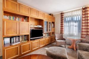 a living room with wooden cabinets and a flat screen tv at Ferienhaus Pöhlbergblick in Großrückerswalde