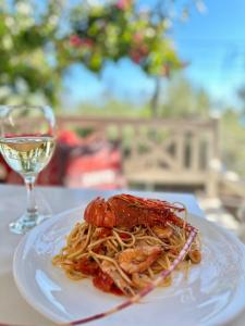 a plate of pasta with shrimp and a glass of wine at Hotel Imperial in Dhërmi