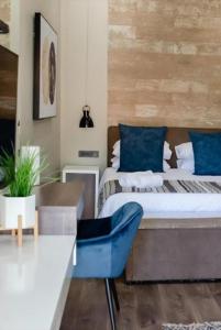 ein Schlafzimmer mit einem Bett und einem blauen Stuhl in der Unterkunft The Royal Guest House in Klerksdorp