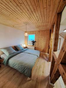 a bedroom with a large bed with a wooden ceiling at FeWo Ellerholz am Müritz Nationalpark in Rechlin
