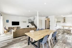 a dining room and living room with a wooden table and chairs at Casa Sant Pere in Sant Pere Pescador