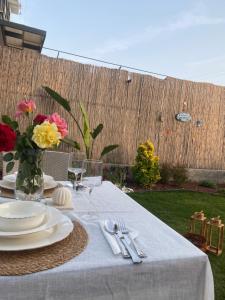 una mesa con platos y un jarrón de flores. en Atli Apart, en Fethiye