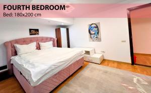 a bedroom with a pink bed in a room at Royal Grand Suite in Cluj-Napoca