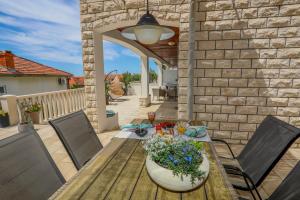 patio con tavolo in legno e fiori di Juric 32 - Boutique Apartments a Hvar