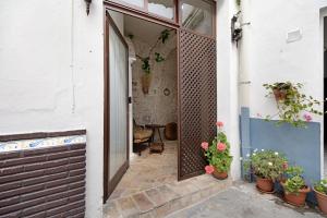 an open door to a patio with potted plants at La cueva de medina-sidonia in Medina Sidonia