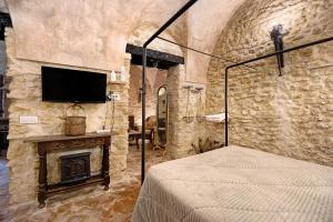 a bedroom with a bed and a fireplace and a tv at La cueva de medina-sidonia in Medina Sidonia
