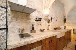 a kitchen with a sink and a stone wall at La cueva de medina-sidonia in Medina Sidonia +15 photos