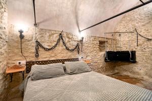 a bedroom with a bed in a stone wall at La cueva de medina-sidonia in Medina Sidonia