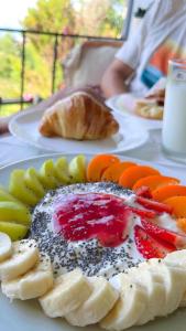 a plate of food with fruit on a table at Hotel Imperial in Dhërmi