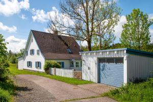 a white house and a garage next to a house at Ferienhaus Allgäuperle in Altusried