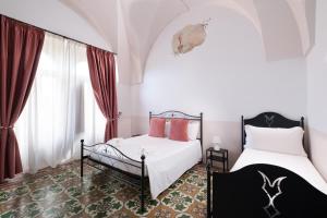 a bedroom with two beds and a window at Masseria Borgo Santuri in Ostuni