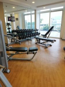- une salle de sport avec des rames de tapis roulants et des chaises dans l'établissement Iloilo Condominiums, à Iloilo