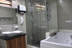 La salle de bains est pourvue d'une douche en verre et d'un lavabo. dans l'établissement Tropicals Resort, 