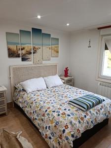 een bed in een slaapkamer met schilderijen aan de muur bij Vivienda vacacional cerca de Bilbao in Galdakao