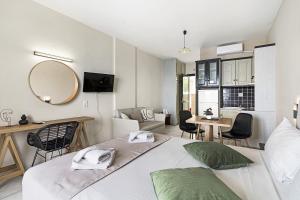 1 dormitorio con 1 cama, mesa y sillas en Sunset Premium Studio B, en Agios Nikitas