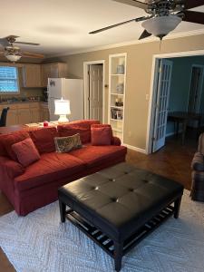 a living room with a red couch and a coffee table at Pool House in Clarksdale