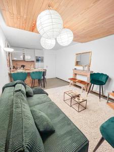 a living room with a green couch and chairs at Refuge Montagnard à Montgenèvre in Montgenèvre +50 photos