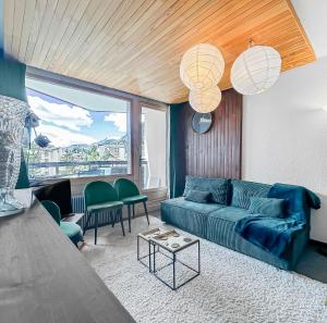 a living room with a blue couch and green chairs at Refuge Montagnard à Montgenèvre in Montgenèvre