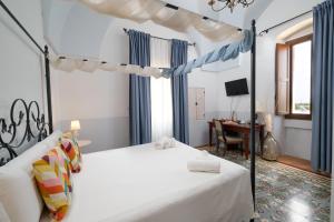 a bedroom with a canopy bed and a desk at Masseria Borgo Santuri in Ostuni +37 photos