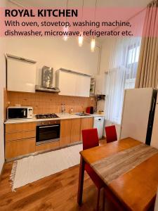 a kitchen with a wooden table and a kitchen counters at Royal Grand Suite in Cluj-Napoca