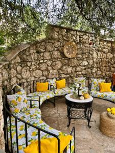 a patio with couches and a table and a stone wall at Hotel Imperial in Dhërmi